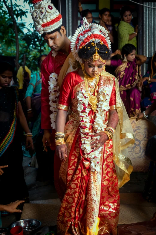 a couple walking through an outdoor ceremony in traditional dress