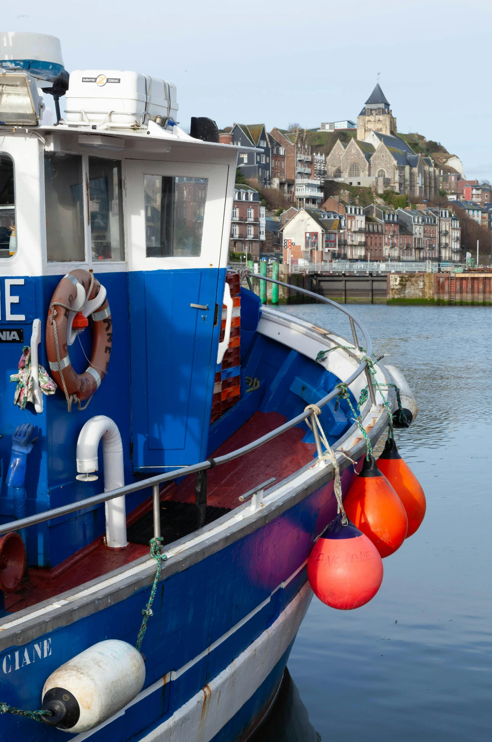 a blue boat docked on a body of water