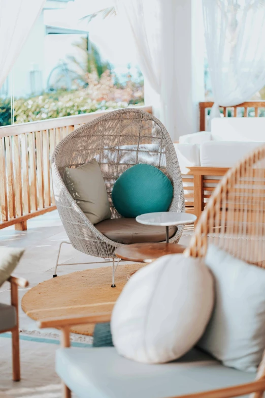 a large wicker chair with green pillows