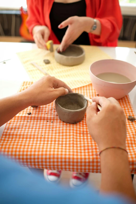 people are doing pottery at the table with one another