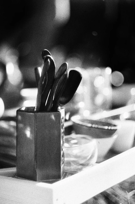 a black and white po of spoons in a square container