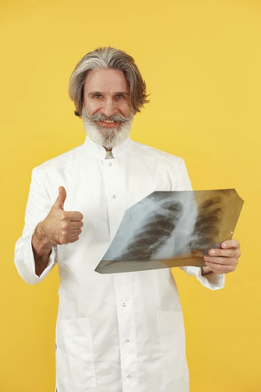 a man with long hair, wearing a white shirt and holding a piece of paper