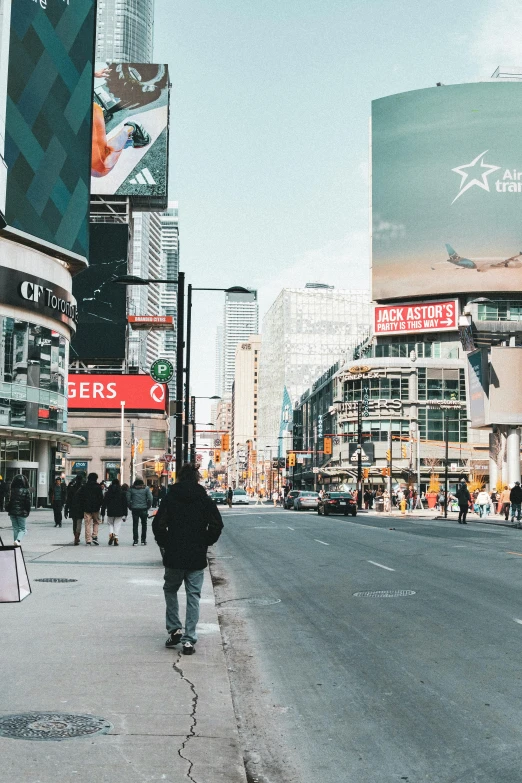 people are walking down a street in the city