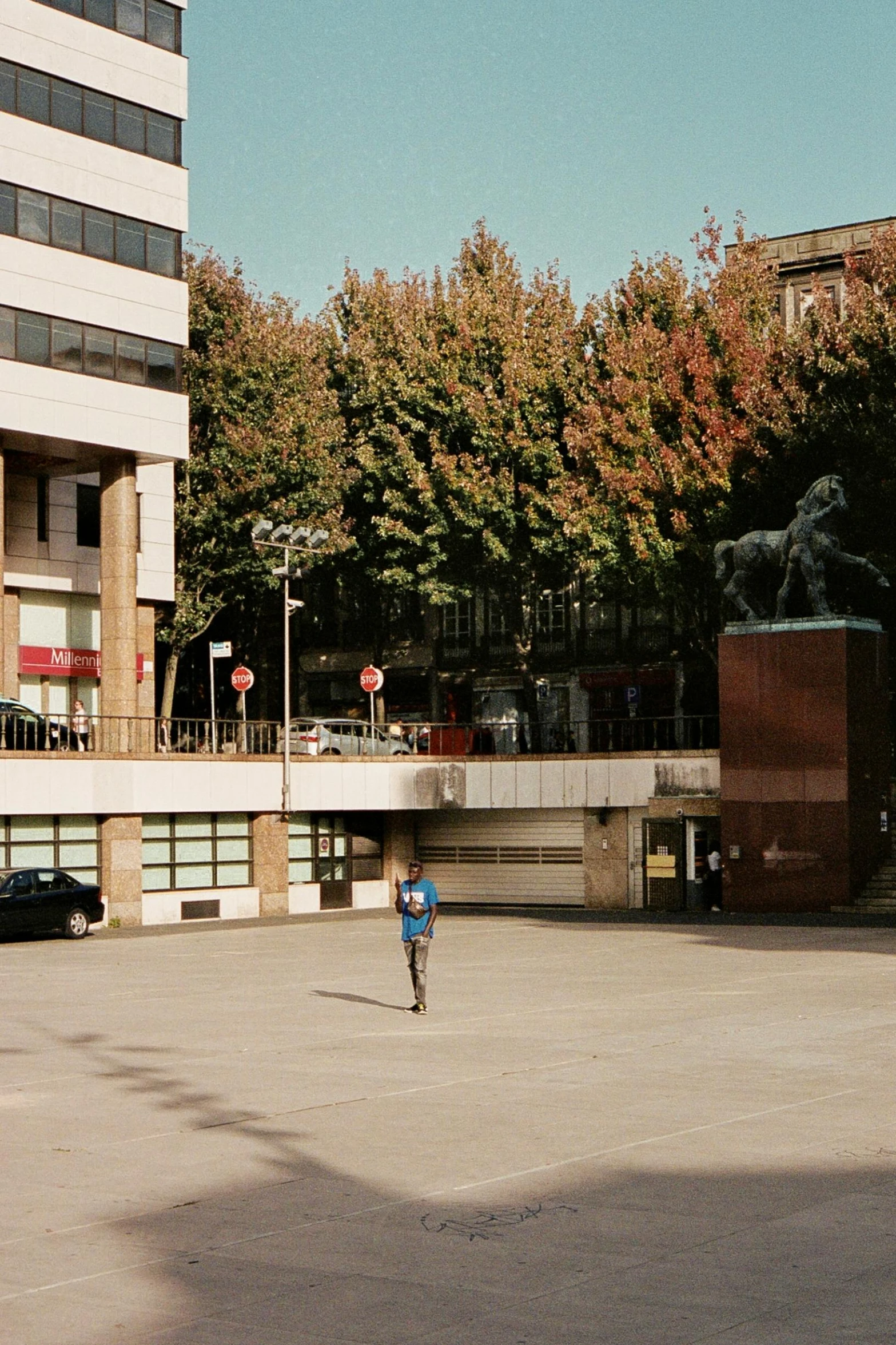 a person running on concrete with a parking lot and bridge in the background