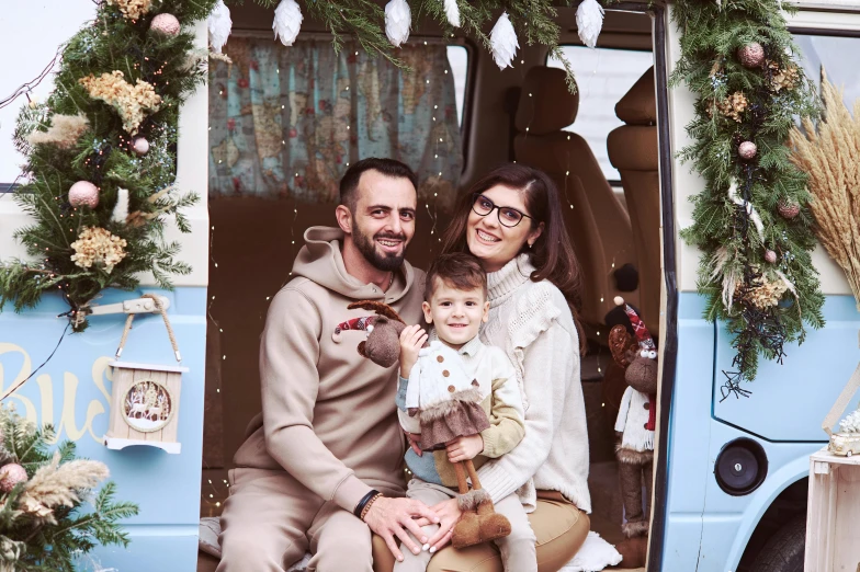 the family is posing for a po by a blue bus