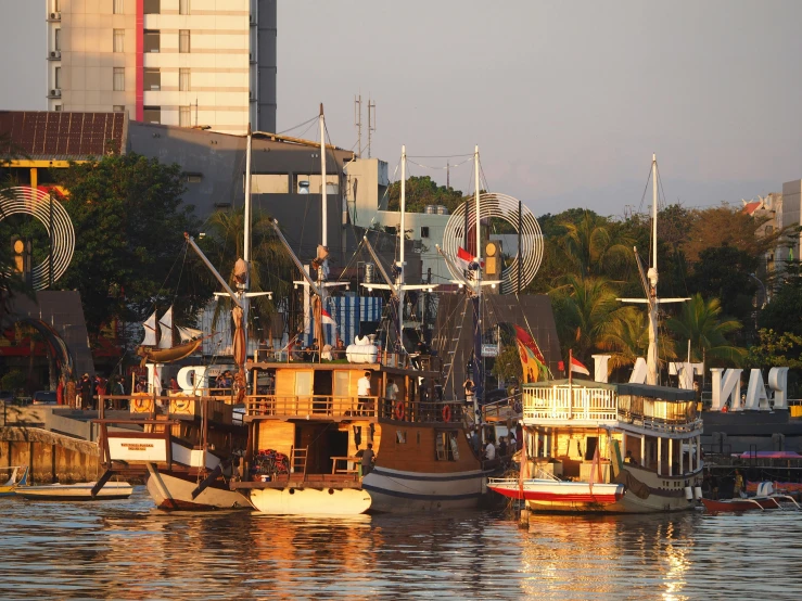 several small boats are docked outside near a large city