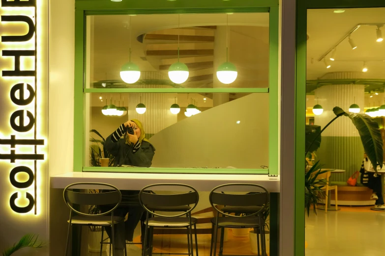 two people are sitting in the window at an outside cafe