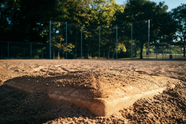 a pile of sand in front of a fence