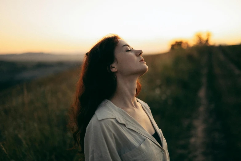 a woman standing in front of a trail at sunset