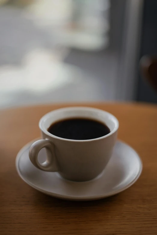 an almost empty coffee cup sitting on top of a wooden table