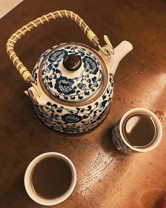 a teapot and cups sitting on a table