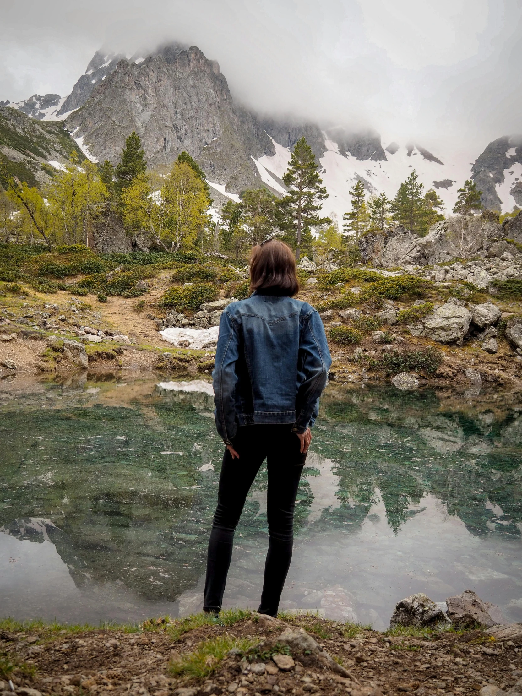 a man stands on a hill above water