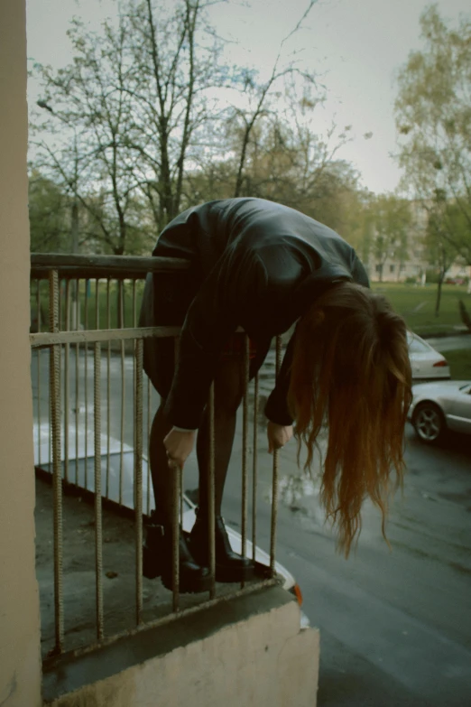 a person is reaching over a fence to the ground