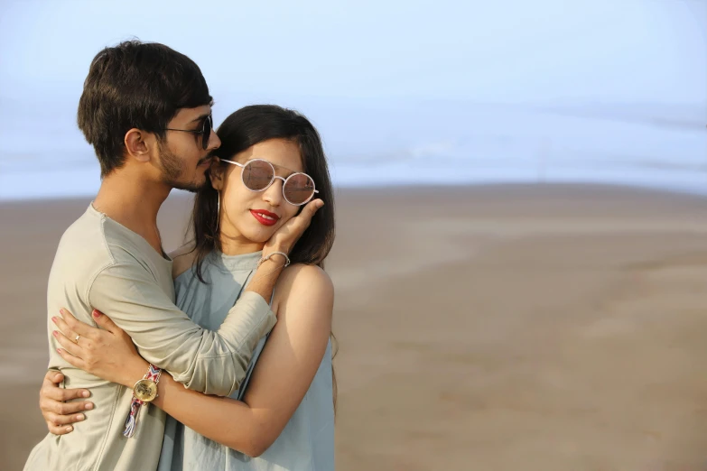 a man kissing a lady on the beach