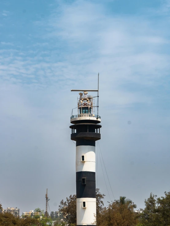 a lighthouse on the ocean surrounded by trees