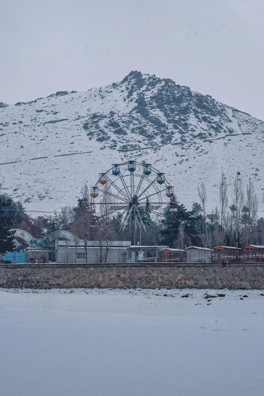 a snowy mountain covered in lots of snow and a ferris wheel