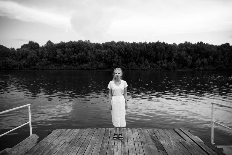 black and white po of woman standing at pier