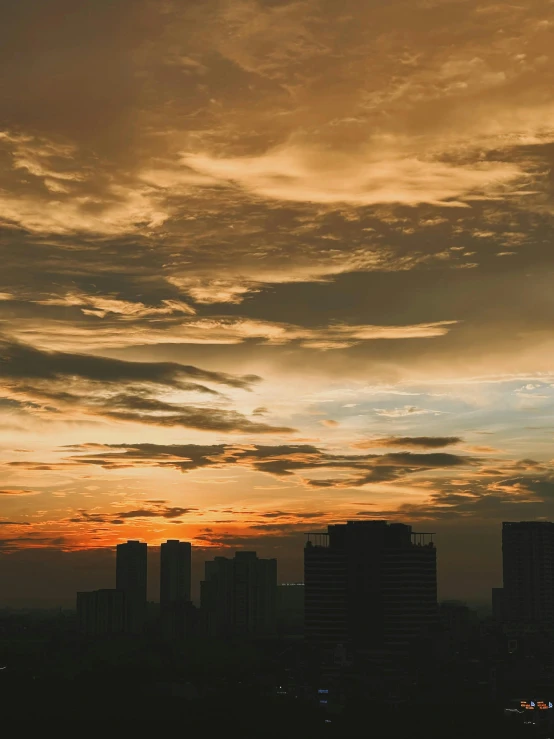 a large airplane flies through the clouds over buildings