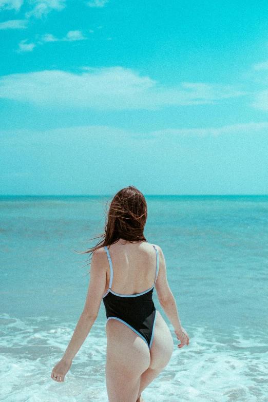 a woman walking along the beach near the water