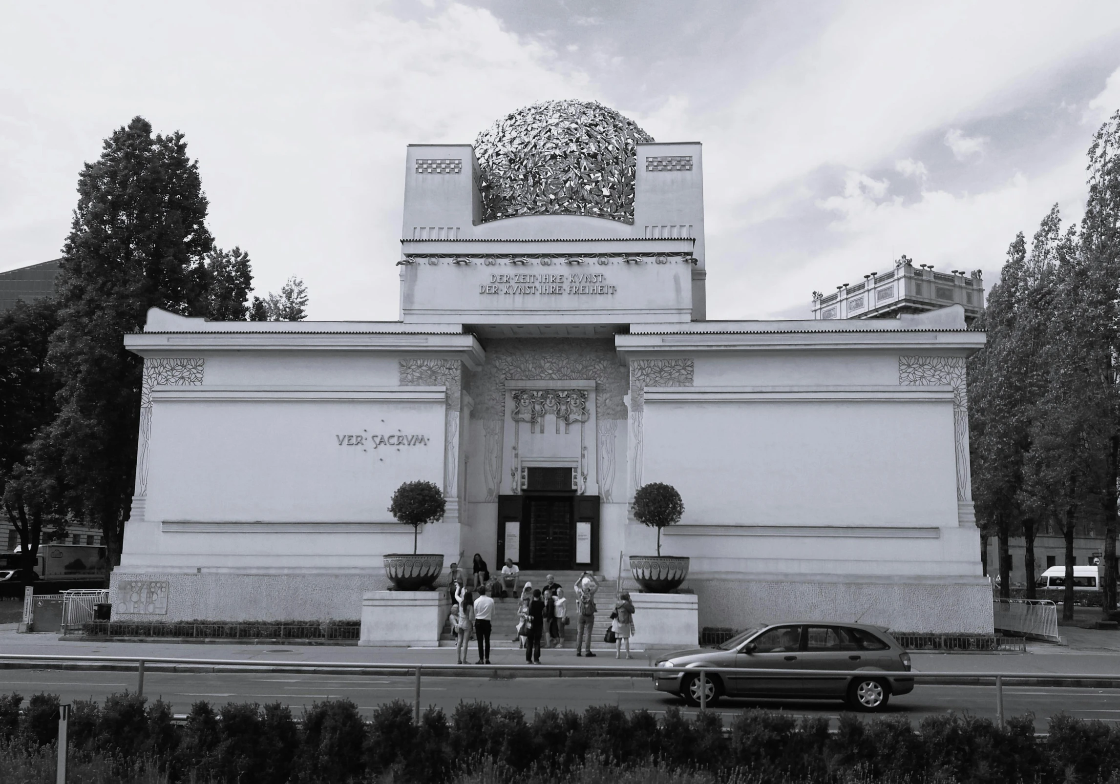 black and white pograph of a building with a car parked in front of it