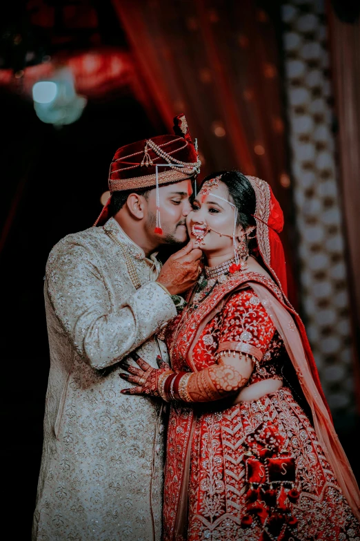 an indian bride and groom in their traditional bridal po