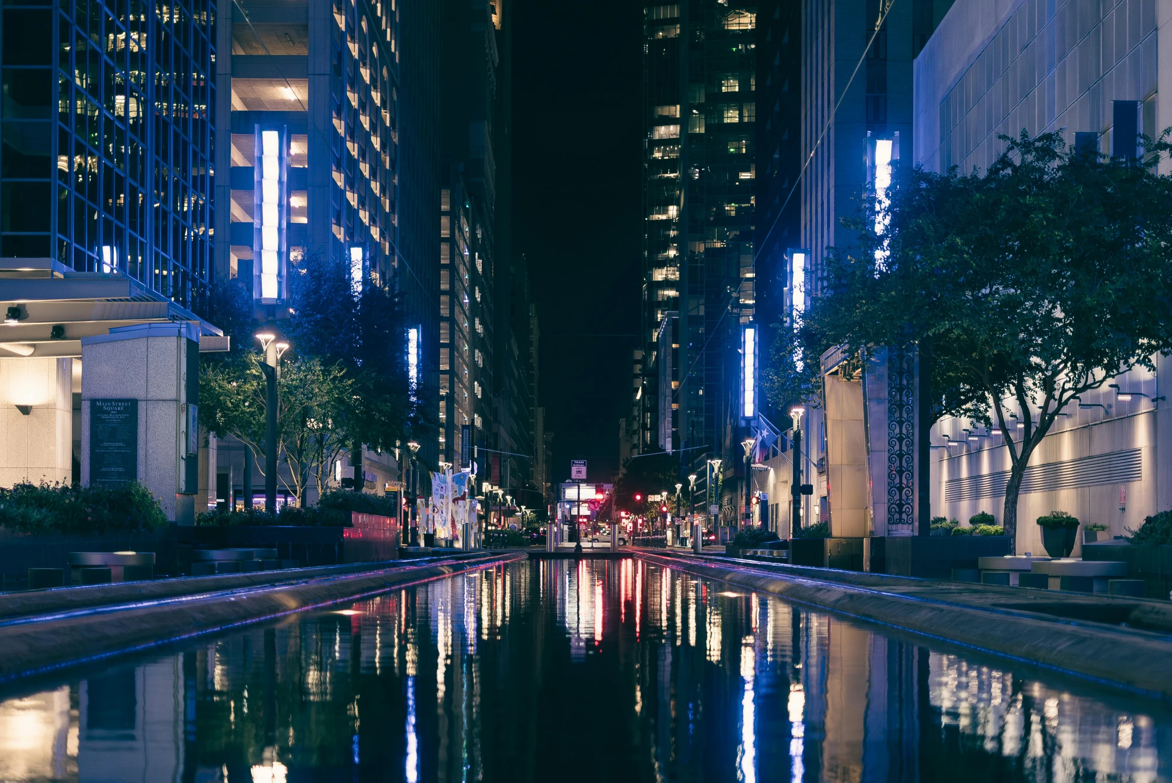 buildings are lit up on both sides of a street