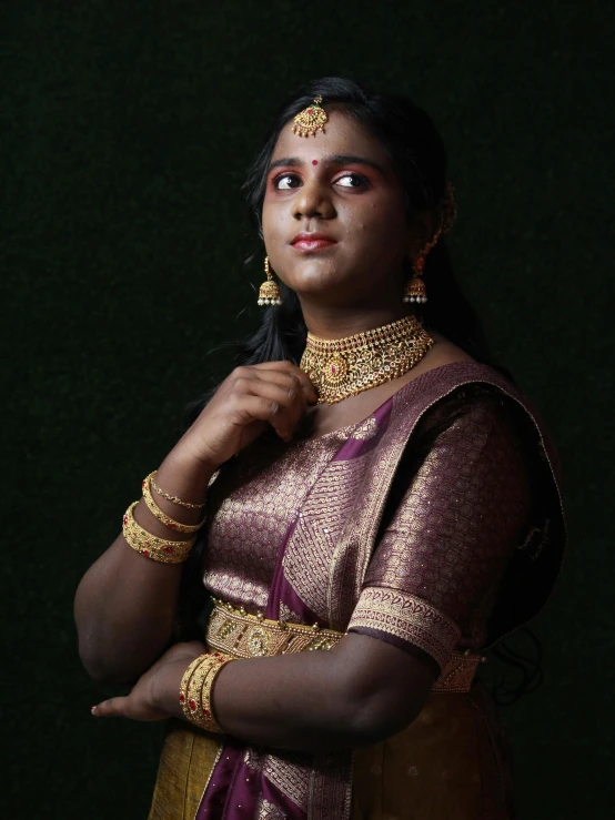 a woman is posing for the camera in her golden jewelry