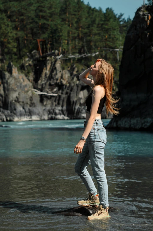 the woman is standing on an old skateboard in the water