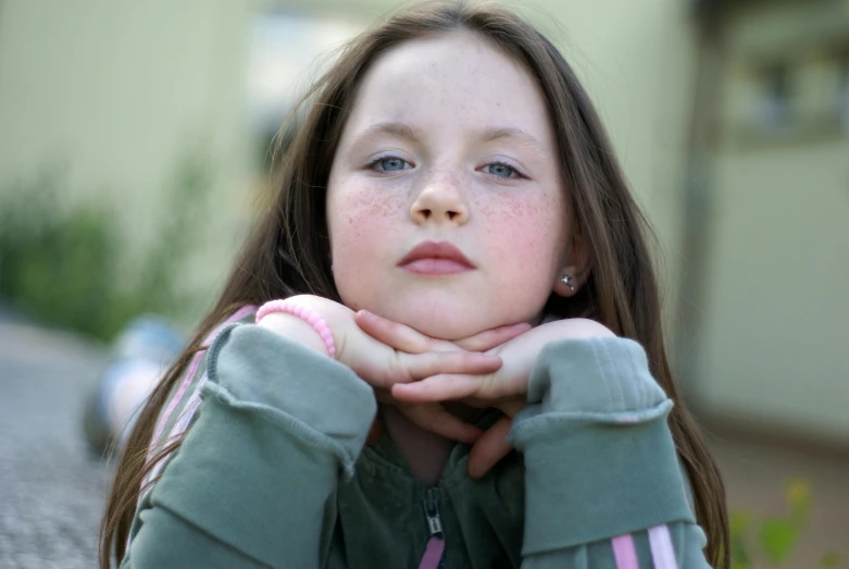 a little girl with her hands near her face