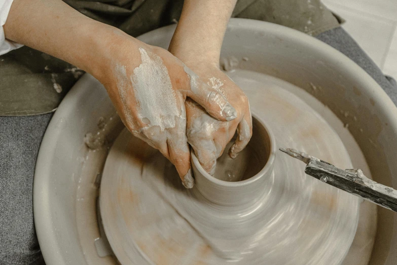 someone making a pottery bowl out of a clay pot