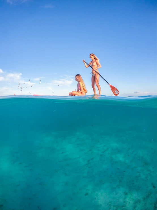 two women in the water paddling their kayaks