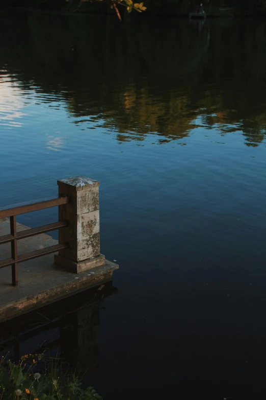 a bench on the edge of a lake next to a dock