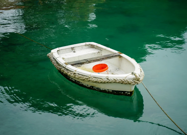 a boat floating in the middle of clear blue water