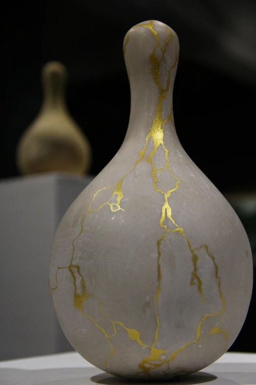 a white and yellow vase is sitting on a table