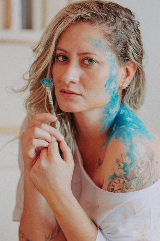 a lady is with blue and pink paint on her face