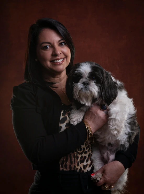 a woman holding a black and white dog