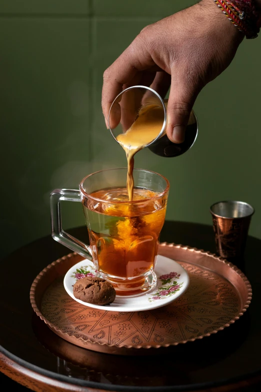 a man pouring a cup of tea in to a cup of water