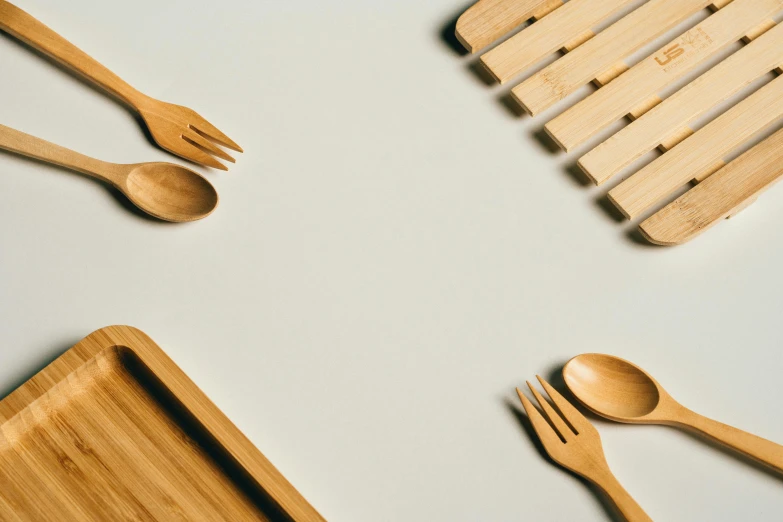 wooden forks, spoons and bamboo trays arranged on a table