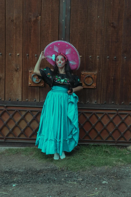 woman with mexican costume holding pink umbrella while standing