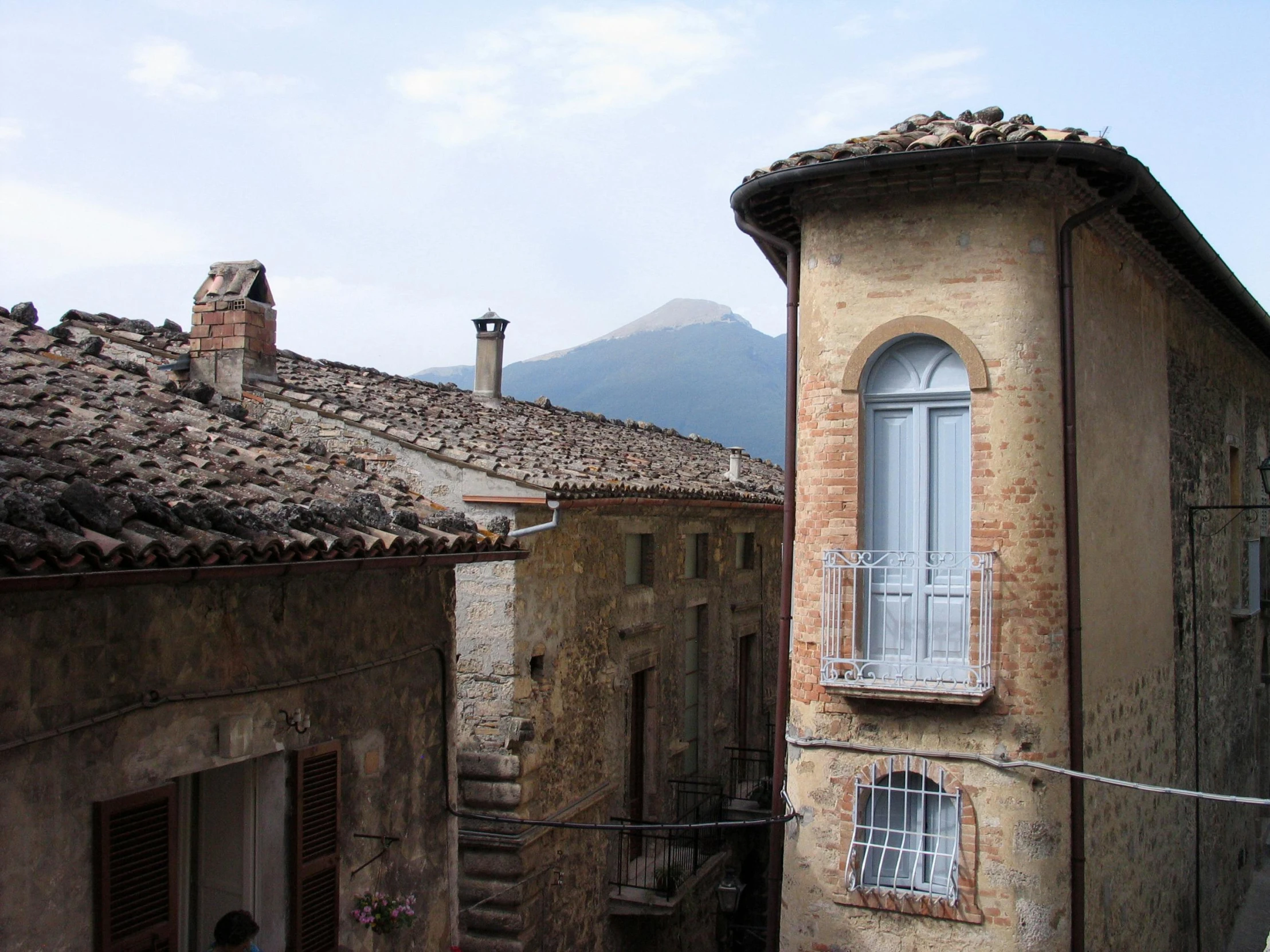 a balcony area in an old fashioned building with a view of mountains