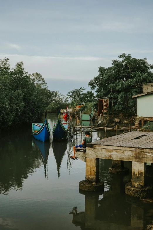 two boats moored in water next to a house