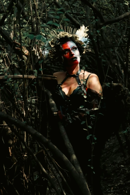 a woman in black lingerie holding an object near many trees