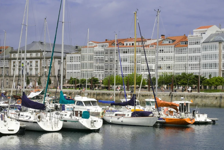 a marina filled with boats of all kinds near a city