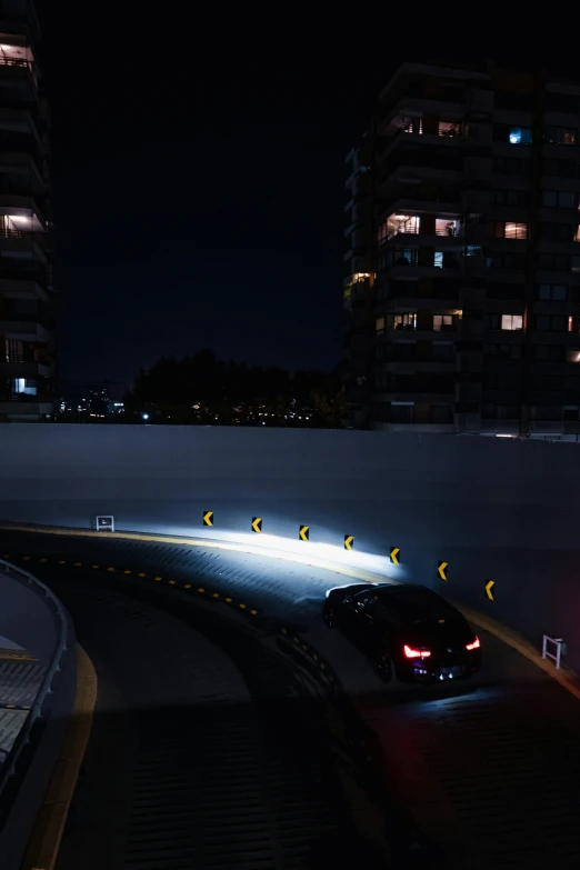 a car drives along a city street at night