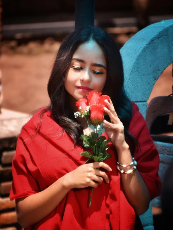 a woman wearing a red outfit is holding roses