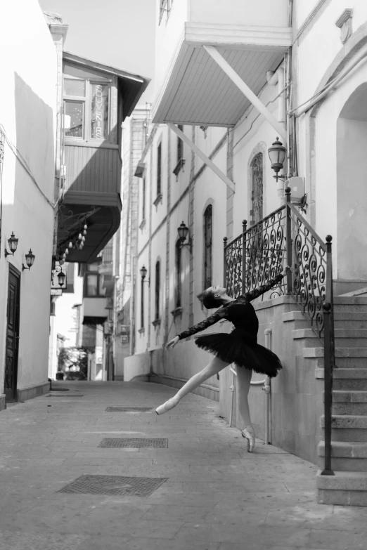 a ballerina practicing ballet move on the street