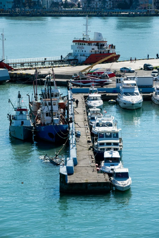 a long dock area has several boats docked on it