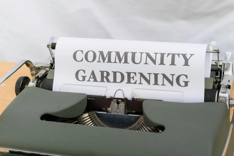 an old typewriter displaying a community gardening sign