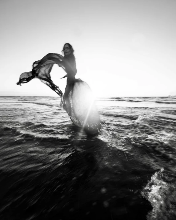 black and white pograph of a woman on a surfboard