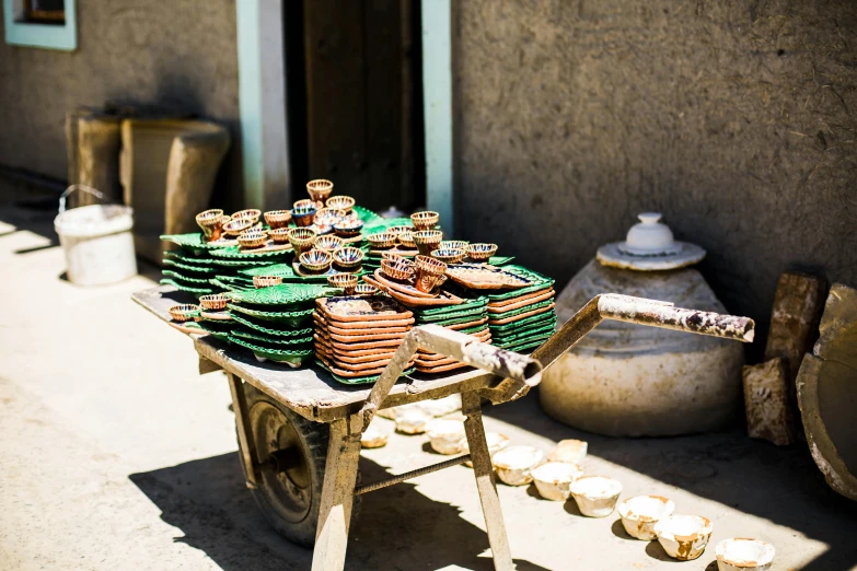 an old wooden cart filled with plates and cups